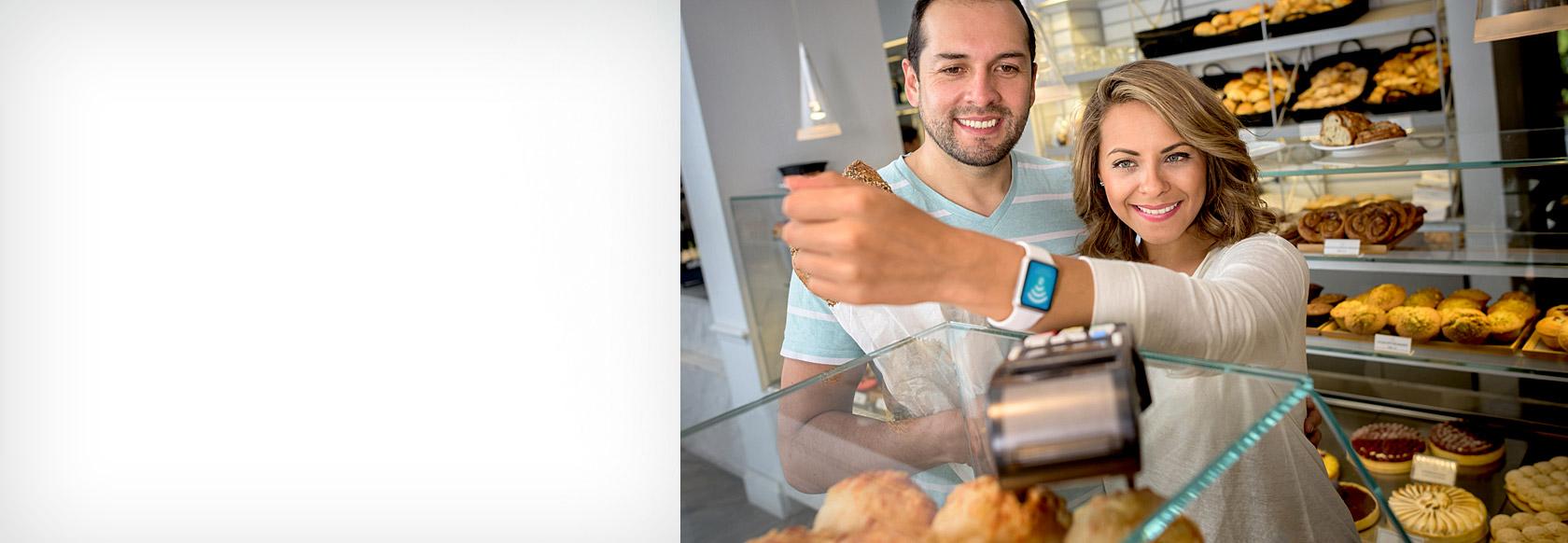 Happy couple using Apple Watch to pay